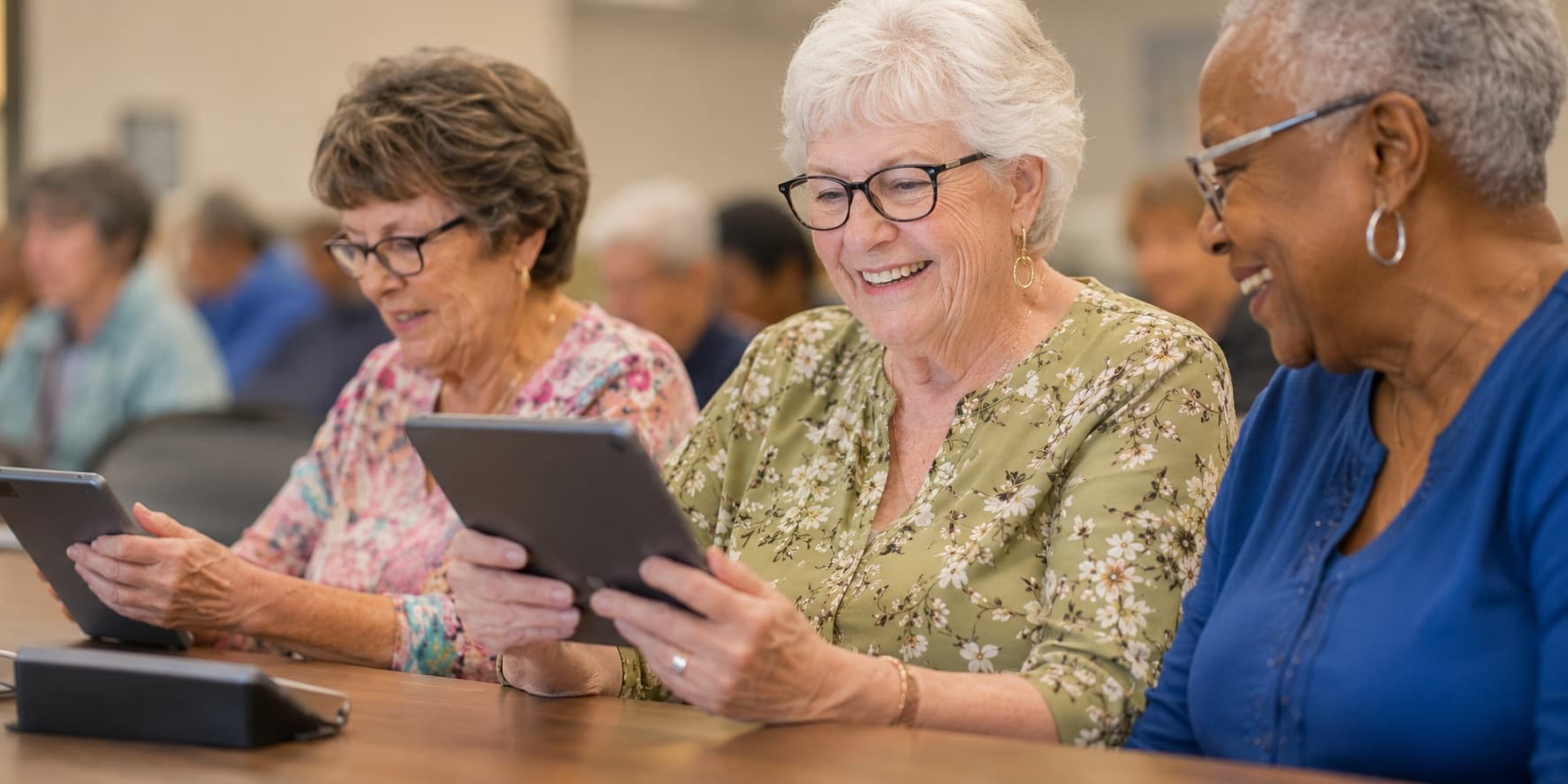 Older adults learning to use tablets together at a GOLD workshop.