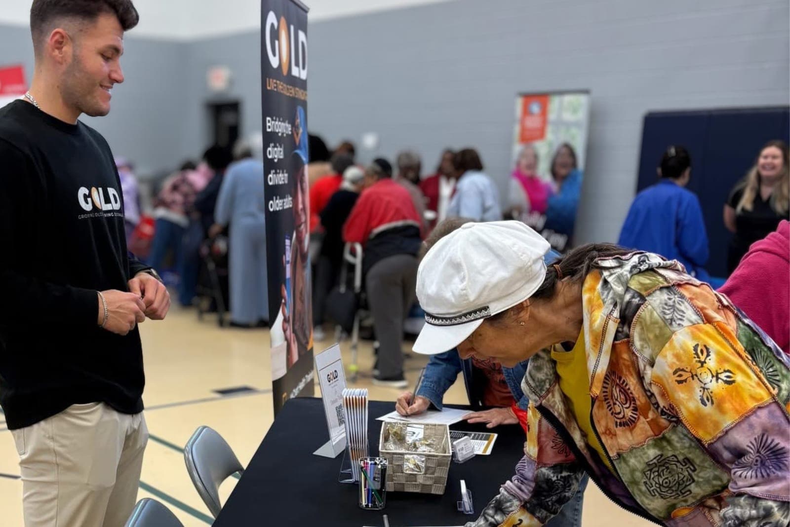 A woman signing up at the GOLD table at a community resource fair